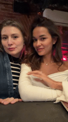 Two women pose for photos at Krasnoyarsk restaurant