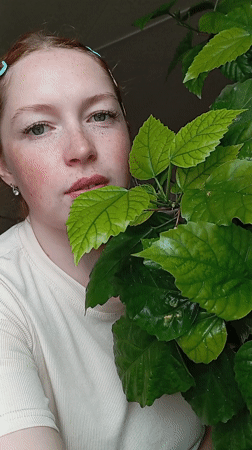 Woman poses with plant in Yurgamysh, Russia