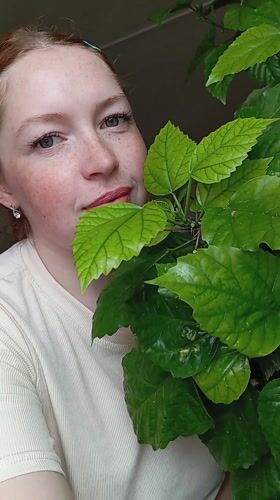 Woman poses with plant in Yurgamysh, Russia