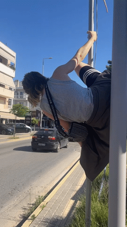 Person pole dances on utility pole in Nafplio Greece