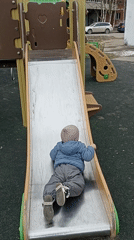Toddler plays at Serpukhov playground while adults gather nearby