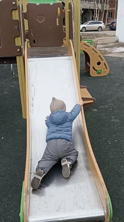 Toddler plays at Serpukhov playground while adults gather nearby