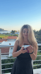 Woman enjoys snacks on Budva balcony overlooking Adriatic Sea
