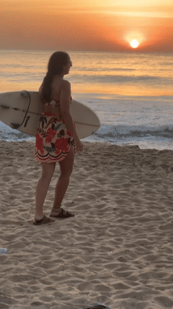 Golden hour on the Sri Lanka coast, surfboard in hand