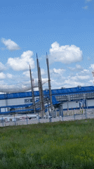 Industrial facility observed with wildflowers under blue skies
