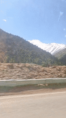 Vehicle travels through mountainous landscape in Tajikistan
