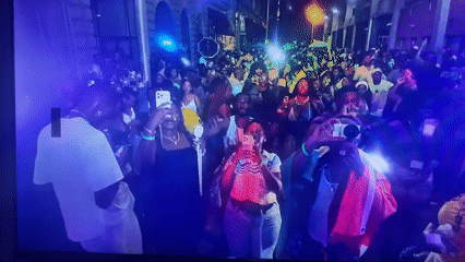 Crowd gathers with phones recording nighttime event in Jos