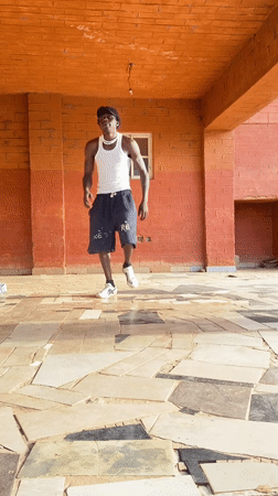 Two men dance on covered patio in Vom, Nigeria
