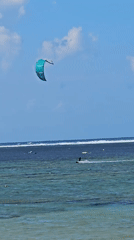 Sunny beach day in Denpasar with watersports and shoreline activity