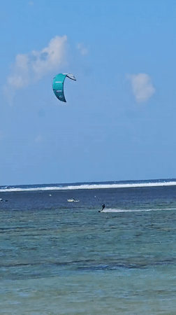 Sunny beach day in Denpasar with watersports and shoreline activity