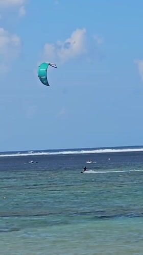 Sunny beach day in Denpasar with watersports and shoreline activity
