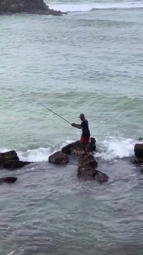 Rock fishing on Sri Lanka's southern coast under stormy skies