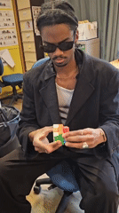 Man solves Rubik's cube in Paris office setting