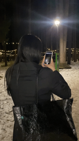 Woman poses for nighttime photo session at winter park in Russia