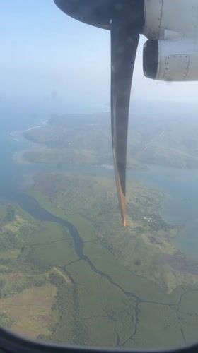 Aerial view captured from aircraft window over Dapa, Philippines
