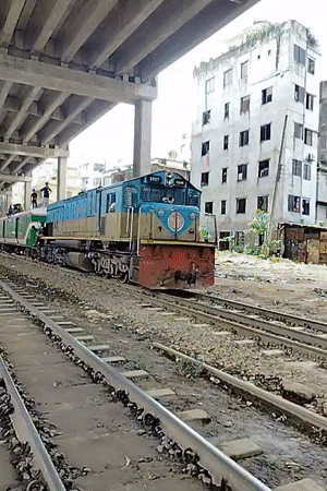 Trains pass under a bridge in Dhaka, riders on top