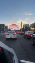 Traffic stops near glowing sphere structure in Las Vegas