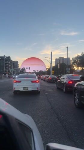 Traffic stops near glowing sphere structure in Las Vegas