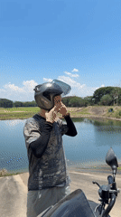 Motorcyclist prepares for departure at Thai lakeside location