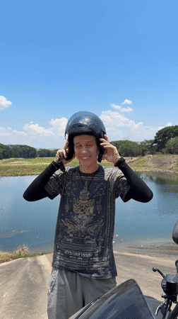 Motorcyclist prepares for departure at Thai lakeside location