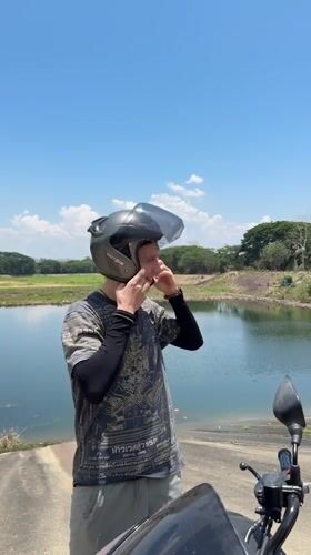 Motorcyclist prepares for departure at Thai lakeside location