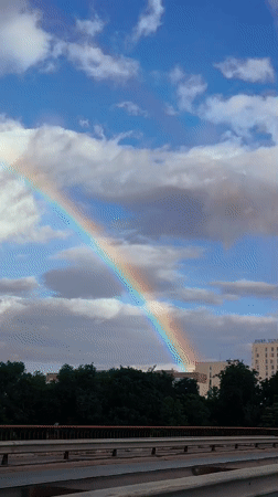 Rainbow over Riga streets on a partly cloudy afternoon