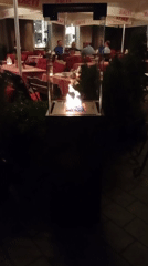 Wrocław restaurant patio at night, fireplace glowing