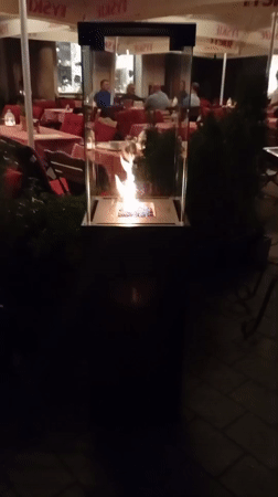 Wrocław restaurant patio at night, fireplace glowing