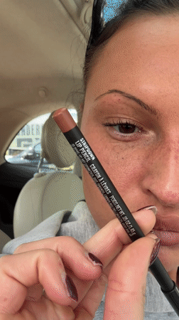 Woman applies MAC lip pencil in car, Tunbridge Wells