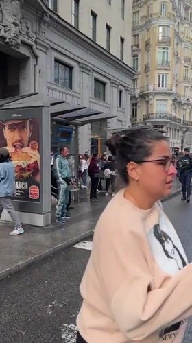Madrid scenes capture parade, rain shower, and street encounter