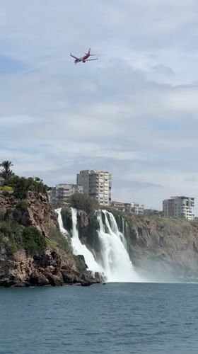 Aircraft flies over coastal waterfall near Antalya, Turkey