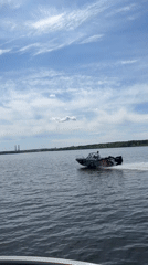 Speedboat crosses lake in sunny conditions near Chaikovsky, Russia