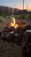 Evening bonfire gathering documented in rural Russian backyard