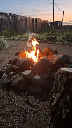 Evening bonfire gathering documented in rural Russian backyard