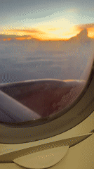 Passenger films colorful sunrise/sunset from airplane over Long Bình