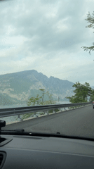 Car travels lakeside road toward Valerana, Italy