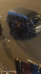 Gray minivan with open hood, occupants inside at night