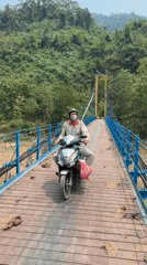 Motorcyclist crosses suspension bridge in Đà Nẵng at dawn