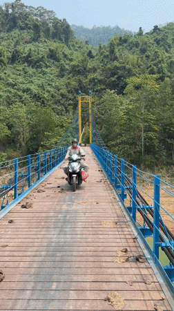 Motorcyclist crosses suspension bridge in Đà Nẵng at dawn