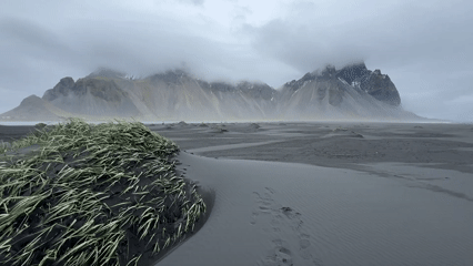 Tourist visits Iceland's black sand beach under cloudy skies