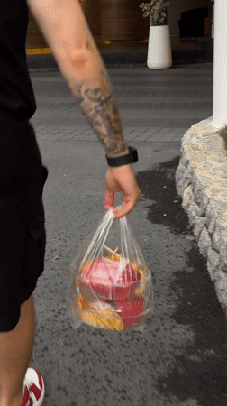 Thai local carries takeout, enjoys cake and fruit