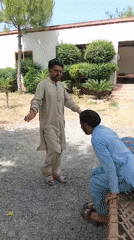 Two men in traditional clothing meet outdoors