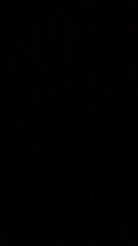 The video begins with a black screen for four seconds. Then, a dark landscape is visible with a faint light in the distance, possibly from the moon or a city. The image is grainy, suggesting it was recorded in low light conditions. The landscape appears to be rolling hills or mountains. The video is very short, ending after five seconds.