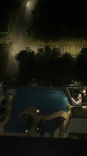Nighttime aerial view of illuminated pool captured from Kuala Lumpur high-rise