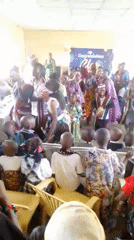 Indoor graduation celebration with robes, dancing, and a trophy moment