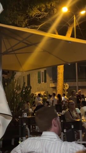 Live music and cafe tables on a summer night in Ospedaletti