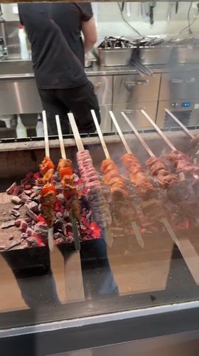 Skewers cooking over hot coals on a Riga grill