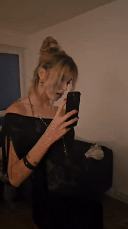 Woman checks smartphone in Pantin apartment Friday evening