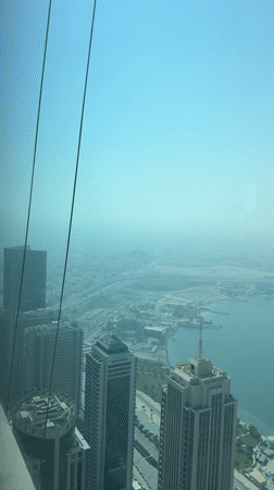 Doha skyline panned from above, haze and glass towers
