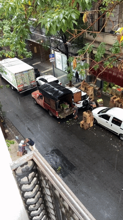 Commercial vehicles unloaded goods on rainy Buenos Aires street